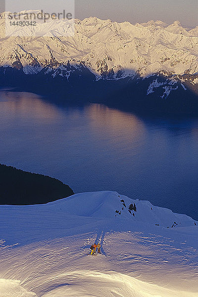 Luftaufnahme von 3 Extremskifahrern auf dem Bergrücken der Kenai Mtns bei Sonnenaufgang mit Resurrection Bay in der Ferne Alaska Winter