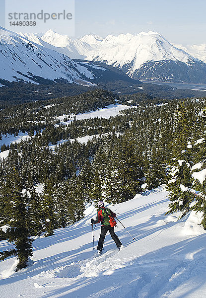 Eine Frau fährt im Winter auf dem Tincan Ridge im Gebiet des Turnagain Pass in Süd-Zentral-Alaska Ski