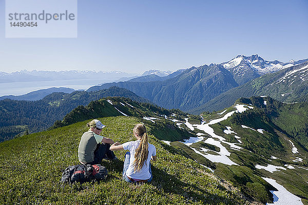 Wanderer rasten und bewundern die Aussicht in den Bergen oberhalb des Amalga Basin im Tongass Forest in der Nähe von Juneau  Alaska.