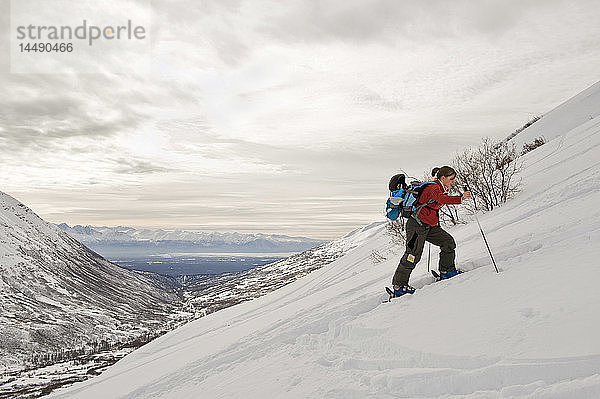 Eine Skitourengeherin beim Aufstieg am Hatcher Pass  Alaska  Winter