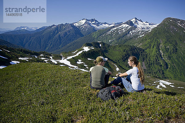 Wanderer rasten und bewundern die Aussicht in den Bergen oberhalb des Amalga Basin im Tongass Forest in der Nähe von Juneau  Alaska.