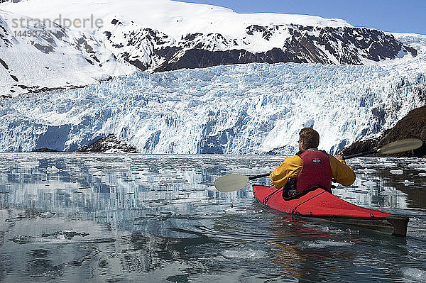 Mann fährt Kajak auf der Eisscholle des Aialik-Gletschers KP AK Spring Kenai Fjords NP