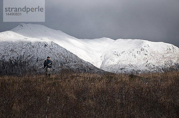 Ein Hirschjäger sucht auf einem Bergrücken in der Nähe des Frazer Lake  Kodiak Island  Südwest-Alaska  nach Wild