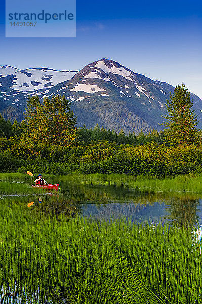 Mann in einem Kajak paddelt auf einem kleinen See im Portage Valley  Southcentral  Alaska  Sommer