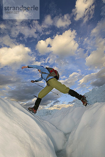 Wanderer springt über die Gletscherspalte Matanuska Glacier SC AK Sommer