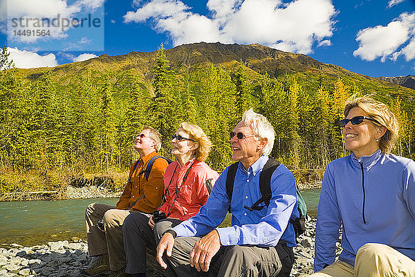 Eine Gruppe älterer Wanderer ruht sich im Herbst am Granite Creek auf der Kenai-Halbinsel in Süd-Zentral-Alaska aus.