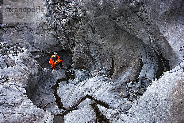 Eine Wanderin klettert einen felsigen Canyon hinauf  der vom sich zurückziehenden Shoup-Gletscher geformt wurde  Prince William Sound  Southcentral  Alaska