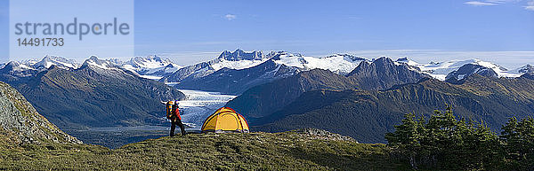 Wanderer neben dem Zelt auf dem Bergrücken mit Blick auf den Mendenhall-Gletscher und die Coast Mountains in der Nähe von Juneau  Alaska  im Sommer