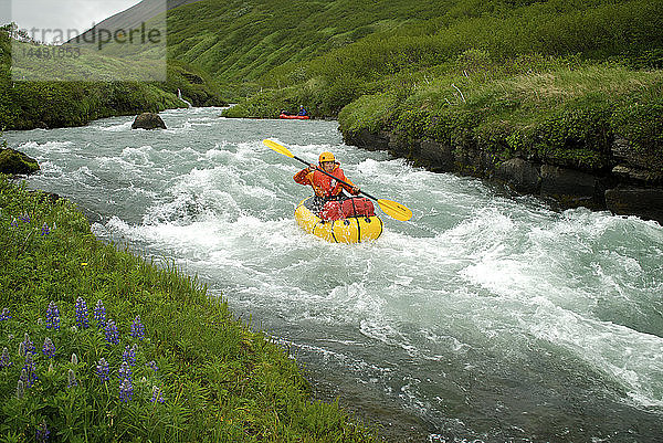 Eine Frau fährt mit einem Floß den Aniakchak River im Aniakchak National Monument and Preserve im Südwesten Alaskas hinunter.