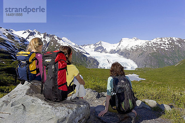 Familie sitzt auf einem Felsen mit Blick auf den Portage Gletscher vom Portage Pass Trail Chugach Mtns Alaska Sommer