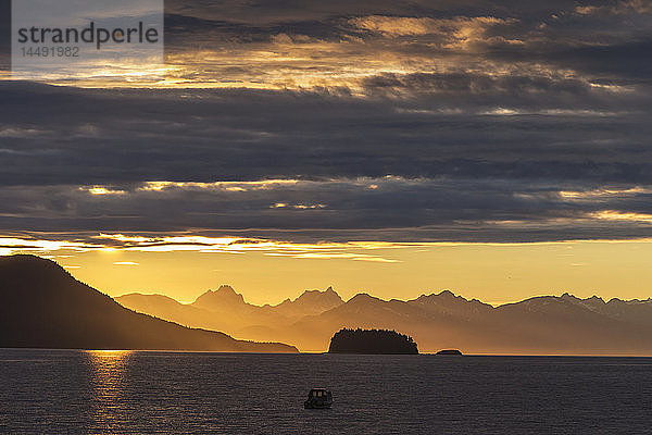 Aussicht auf den Sonnenuntergang in der Favorite Passage  die Chilkat Mountains und ein Fischerboot im Schatten  Inside Passage  Südost-Alaska