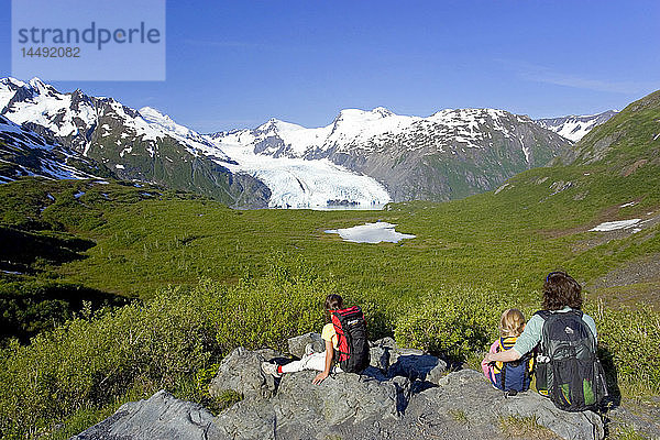 Familie sitzt auf einem Felsen mit Blick auf den Portage Gletscher vom Portage Pass Trail Chugach Mtns Alaska Sommer
