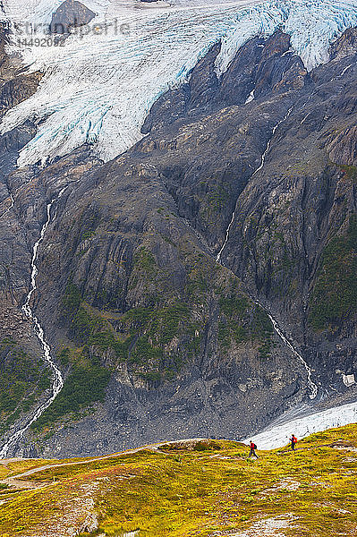 Ein Mann und eine Frau wandern auf dem Harding Icefield Trail mit dem Exit Glacier im Hintergrund  Kenai Fjords National Park  Kenai Penninsula  Southcentral Alaska