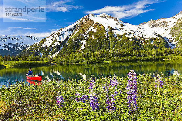 Person beim Kanufahren auf einem kleinen See im Portage Valley des Chugach National Forest im Frühling in Süd-Zentral-Alaska