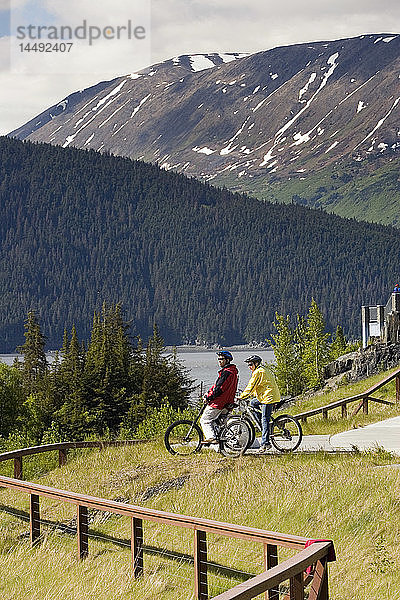 Junges Paar Fahrräder auf Pfad @ Bird Pt Rest Stop AK SC Turnagain Arm Chugach Mtns Sommer