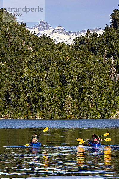 Kajakfahrer auf dem Big River Lakes mit den Chigmit Mountains im Hintergrund in der Redoubt Bay State Critical Habitat Area im Sommer in Süd-Zentral-Alaska