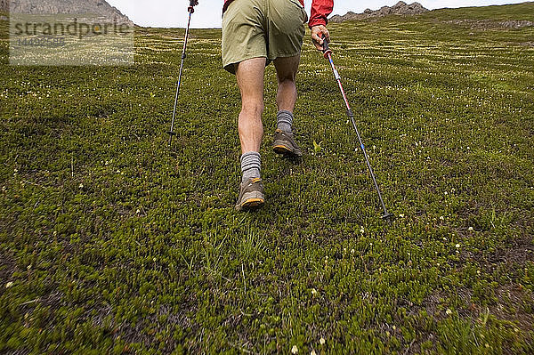 Wanderer läuft bergauf in den Chugach Mountains auf einem 32 Meilen langen Verbindungsweg zwischen den Gipfeln der Chugach Front Range in Southcentral Alaska