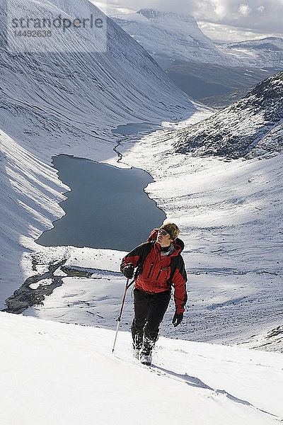 Mann klettert auf den schneebedeckten Berg Kebnekaise