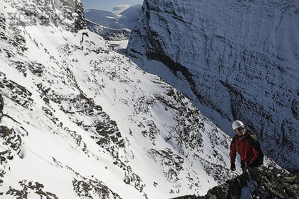 Mann klettert auf den schneebedeckten Berg Kebnekaise