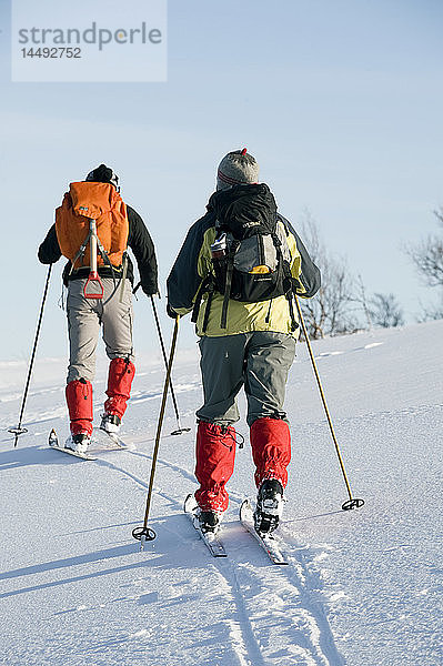 Zwei Personen beim Skifahren  Rückansicht