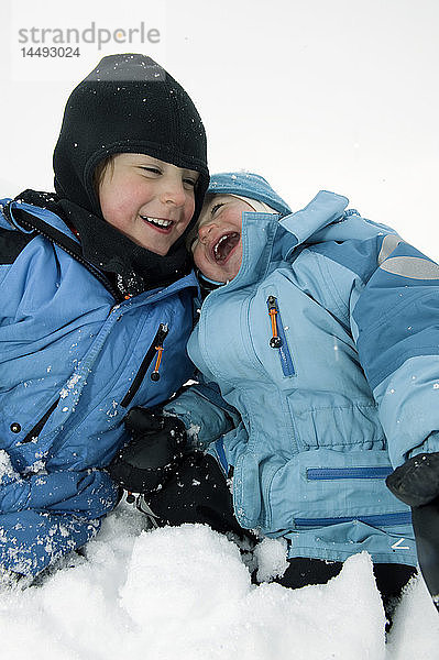 Junge und Mädchen spielen im Schnee