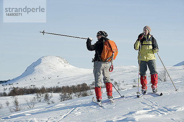 Mann und Frau beim Skifahren in schneebedecktem Gebiet