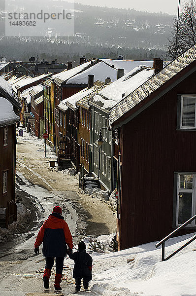Mutter und Kind gehen eine Straße entlang  Norwegen.
