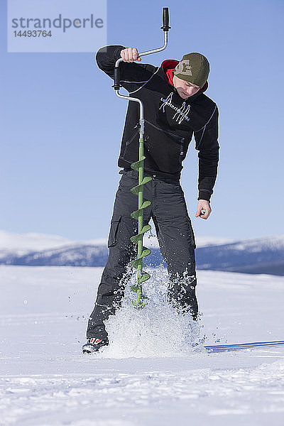 Ein Jugendlicher angelt auf dem Eis  Schweden.