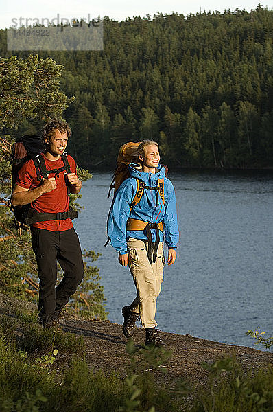 Ein Mann und eine Frau gehen an einem See spazieren  Schweden.