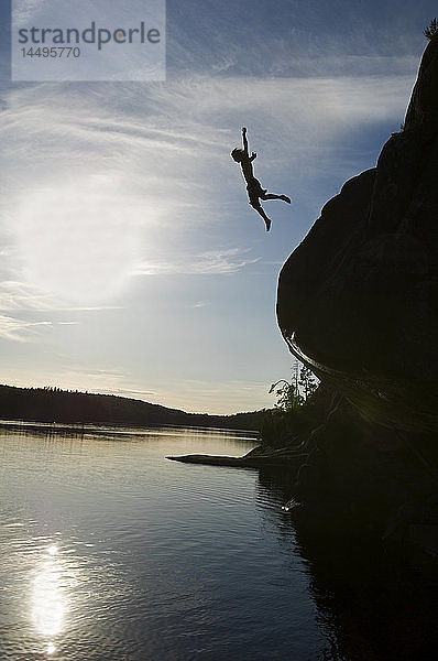 Ein Mann springt von einer Klippe  Schweden.