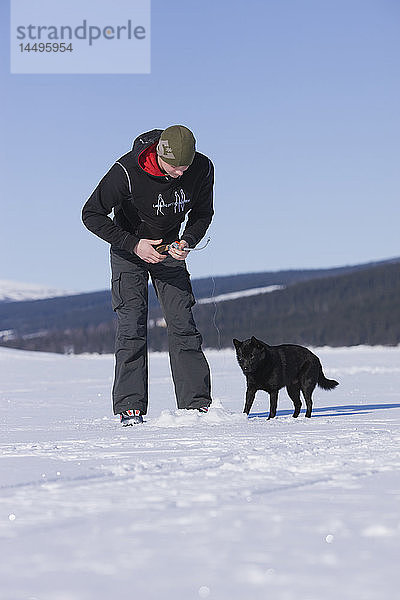 Ein Jugendlicher angelt auf dem Eis  Schweden.