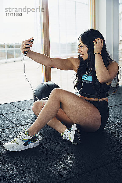Frau nimmt Selfie im Fitnessstudio
