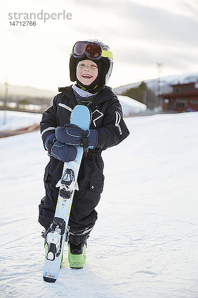 Lächelnder Junge mit Skiern