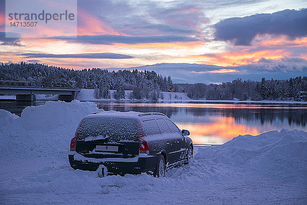 Auto am See bei Sonnenuntergang