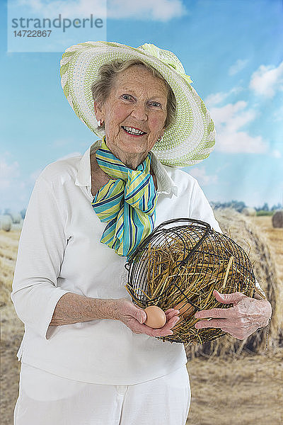Eine ältere Frau sammelt frische Eier.