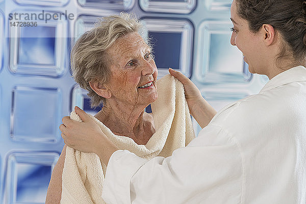 Krankenschwester hilft einer älteren Frau beim Waschen.