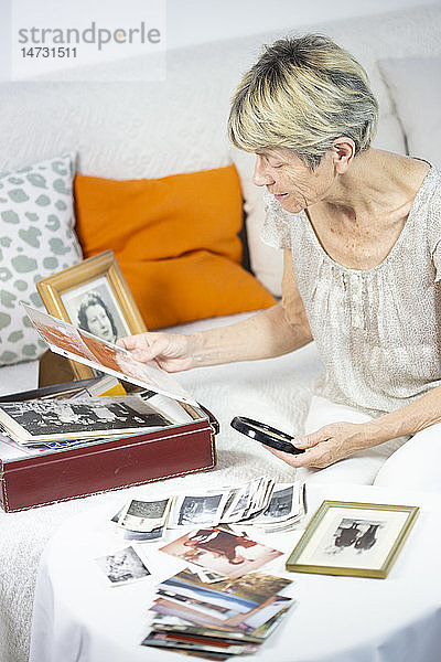 Alte Frau schaut sich Fotos an.