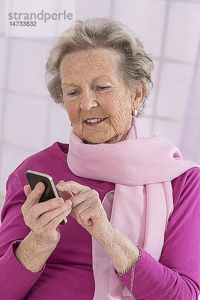 Eine ältere Frau benutzt ein Smartphone.