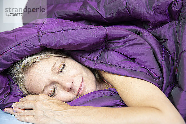 Eine Frau schläft in einer Bettdecke.