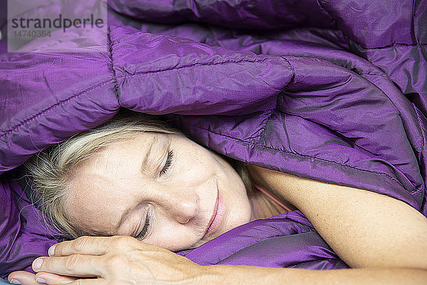 Eine Frau schläft in einer Bettdecke.