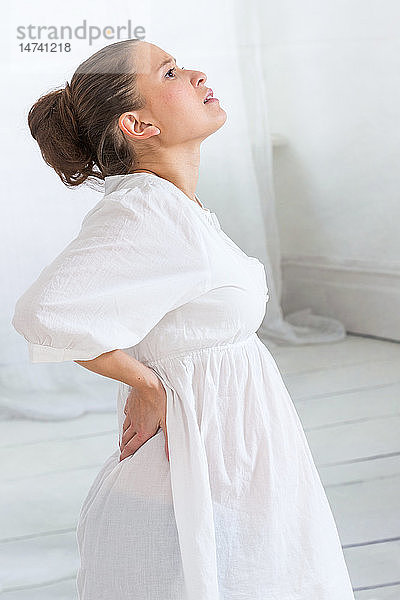Schwangere Frau mit Schmerzen im unteren Rückenbereich