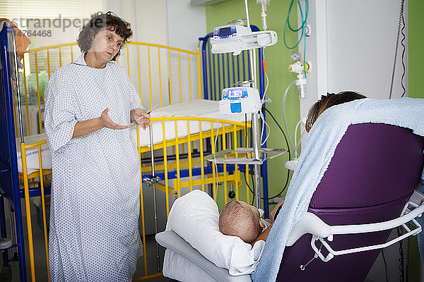 Reportage aus der Kinderabteilung eines Krankenhauses in Haute-Savoie  Frankreich. Ein Arzt spricht mit der Mutter eines Babys im Krankenhaus.