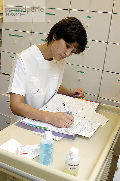 Krankenschwester beim Ausfüllen einer medizinischen Akte.