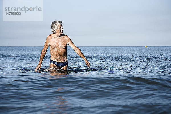 ÄLTERE PERSON AM MEER