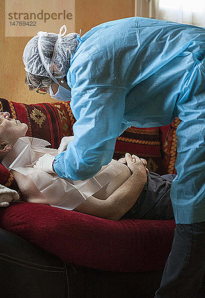 Reportage über einen häuslichen Pflegedienst in Savoie  Frankreich. Eine Krankenschwester wechselt bei einer Krebspatientin den Chemotherapie-Tropf.