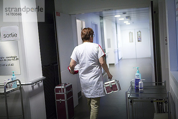 Reportage in der onkologischen Abteilung einer Tagesklinik in Frankreich. Die Hilfskrankenschwester Marie-Cecile arbeitet hier drei Tage in der Woche als Krankenhauskosmetikerin. Sie bietet krebskranken Frauen Schönheitsbehandlungen und Lösungen zur Bewältigung der Nebenwirkungen von Krebsbehandlungen an. Diese Momente eignen sich gut für persönliche Gespräche. Sie gibt einer Patientin eine Schönheitsbehandlung während einer Chemotherapie.