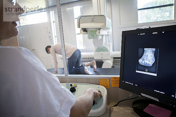 Reportage in einem Radiologiezentrum in Haute-Savoie  Frankreich. Ein Techniker röntgt den Fuß eines Patienten  der wegen eines Hallux valgus operiert wurde.