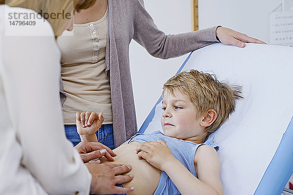 Ein Arzt untersucht den Unterleib eines Kindes.