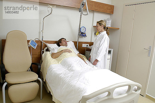Eine Krankenschwester unterhält sich mit einem Patienten.