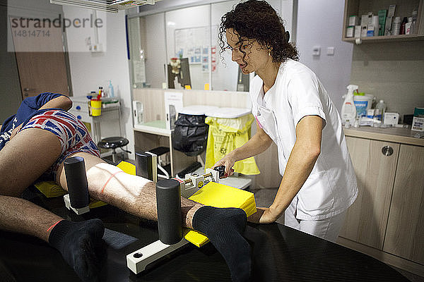 Reportage in einem Zentrum für Radiologie in Hochsavoyen. Ein Techniker führt eine dynamische Röntgenaufnahme des Knies nach einem Bänderriss durch.